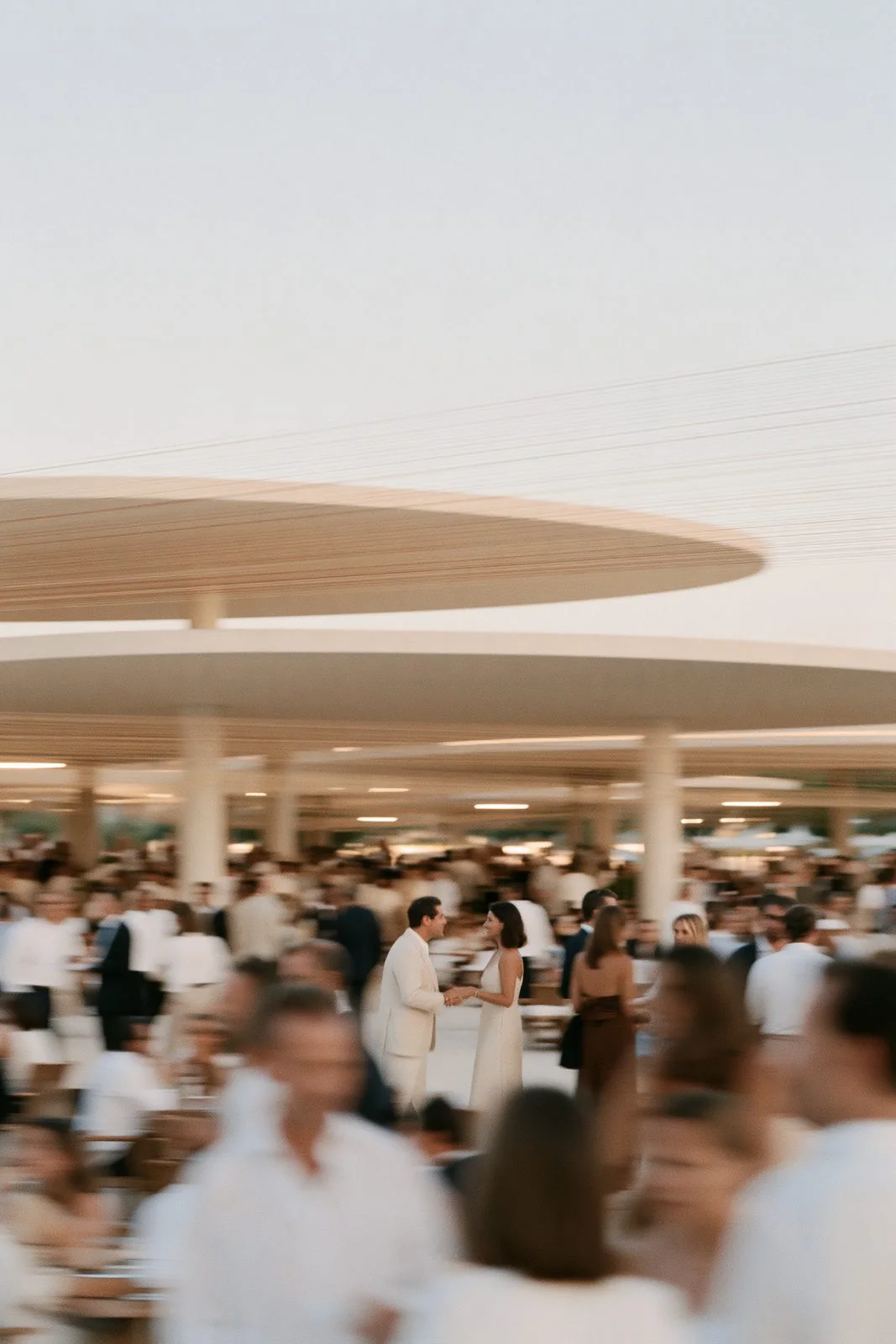 Members in white gathered under an open pavilion